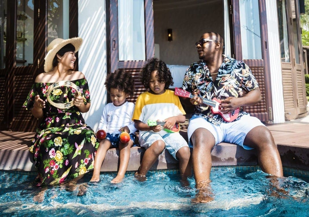 Family playing in a pool 11860 Vista Del Sol, Ste. 128 A Few Ways to Manage Chronic Back Pain During Summer