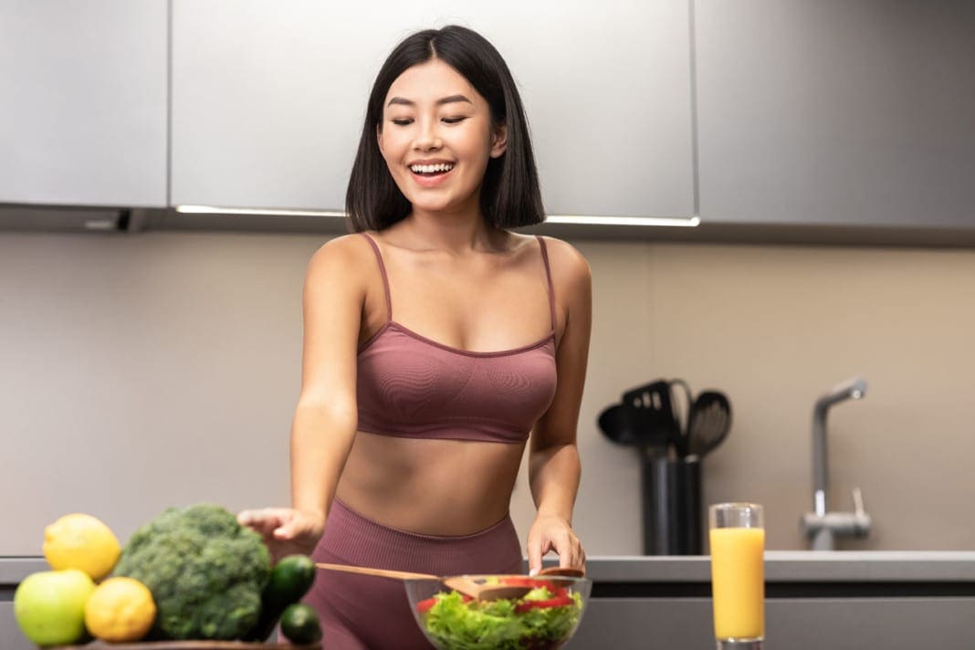 Asian Woman In Fitwear Cooking Salad For Dinner In Kitchen 11860 Vista Del Sol, Ste. 128 Superfoods Can Help Achieve Optimal Health