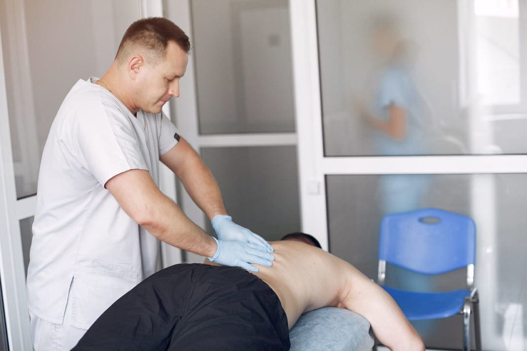 The doctor massages the man in the hospital 11860 Vista Del Sol, Ste. 128 Chiropractic Techniques: Spinal Manipulation