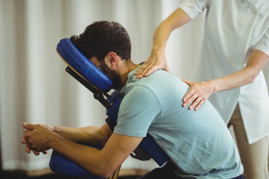 Physiotherapist giving back massage to a patient 11860 Vista Del Sol, Ste. 128 Young Adult Degenerative Disc Disorder and Optimal Spine Health