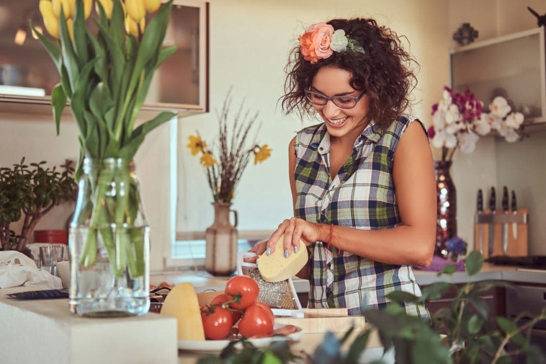 Charming curly Hispanic girl cooking in her kitchen. 11860 Vista Del Sol, Ste. 128 Calcium and Vitamin D for Optimal Bone Health