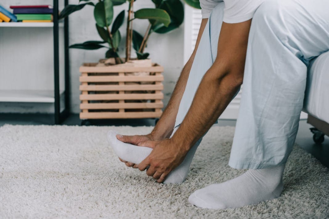 cropped shot of man sitting on bed and suffering from foot pain 11860 Vista Del Sol, Ste. 128 Inflamed Plantar Fascia, Foot/Heel Pain, and Chiropractic