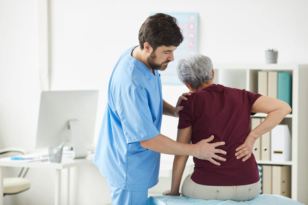 Doctor examining the patient's back 11860 Vista Del Sol, Ste. 128 Cauda Equina Syndrome Nerve Compression Chiropractic Diagnosis