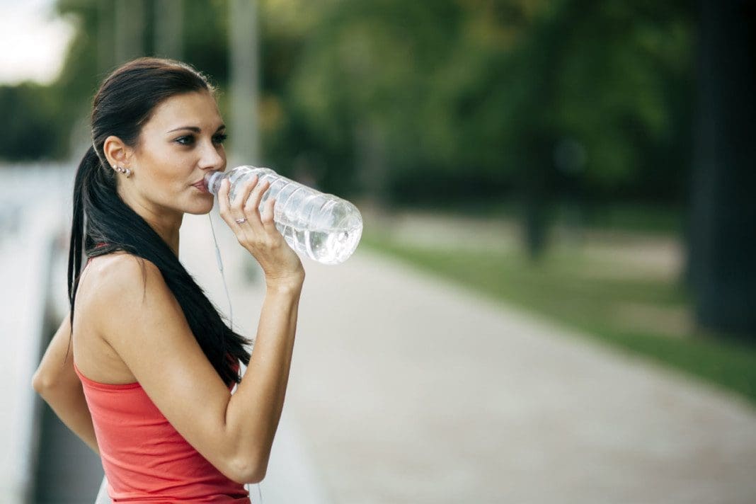 Thirsty woman drinking water to recuperate