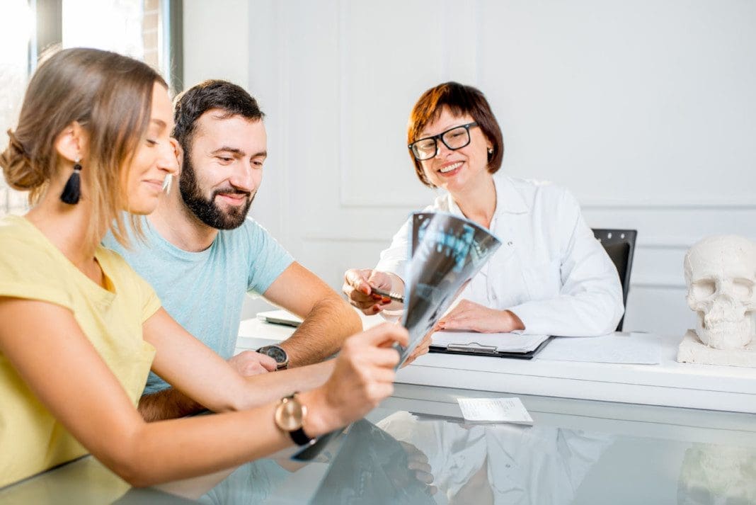 Young couple having a consultation with senior doctor