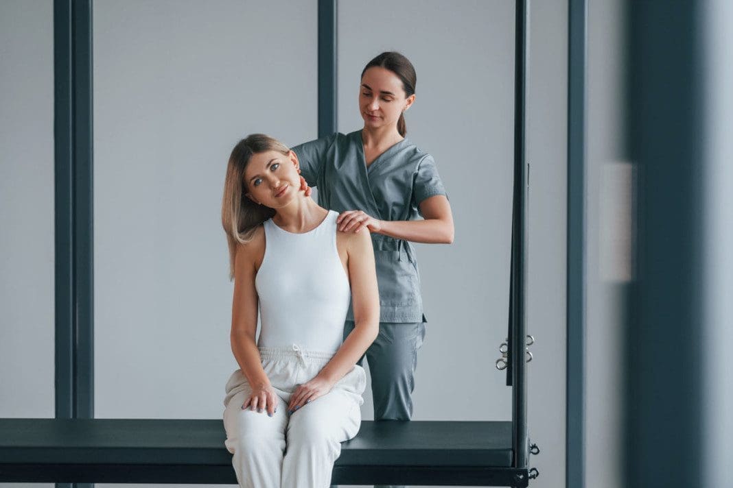 Neck exercises. Woman is in health center getting help by doctor