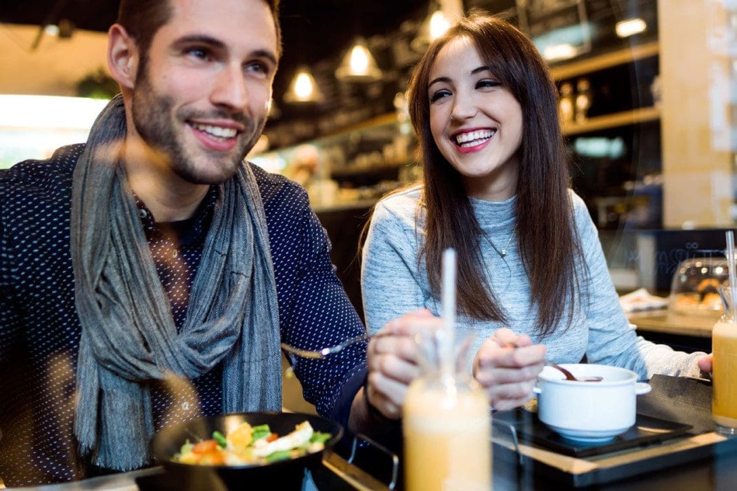 Beautiful young couple eating in restaurant.