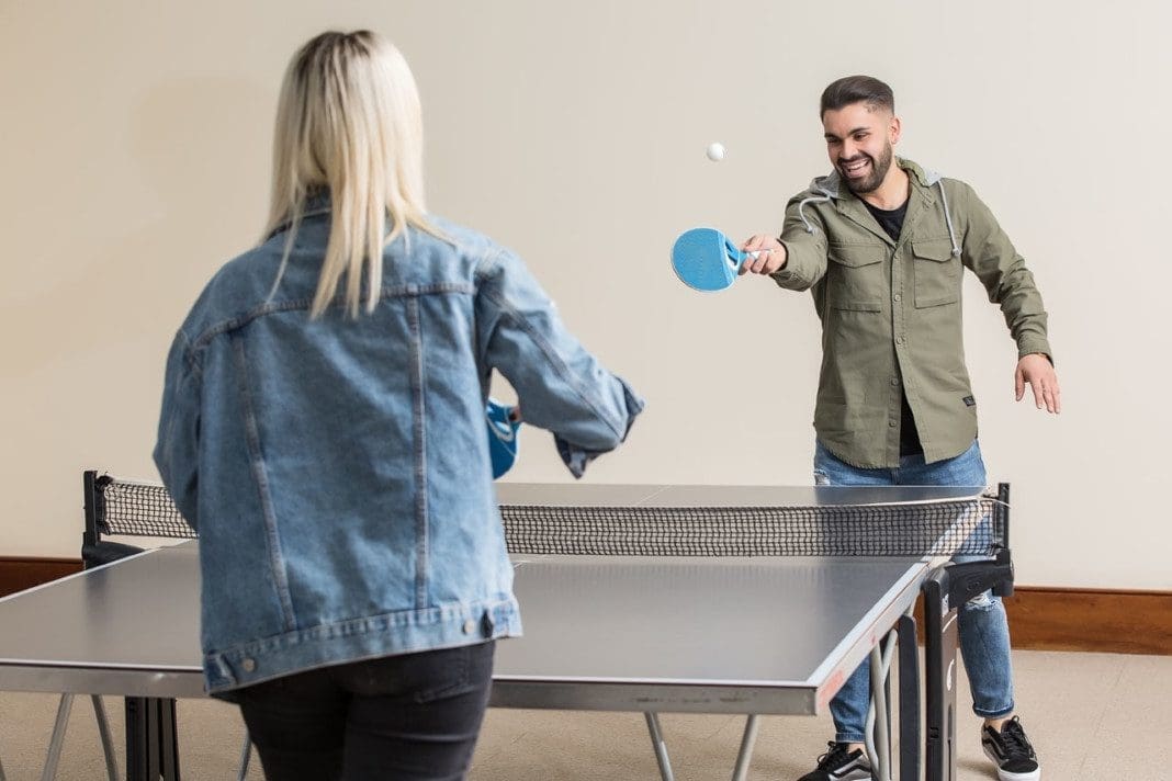 Cheerful friends playing ping pong