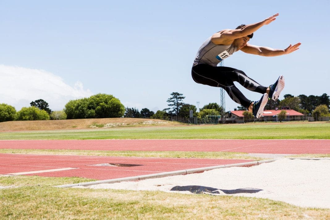 Athlete performing a long jump during a competition
