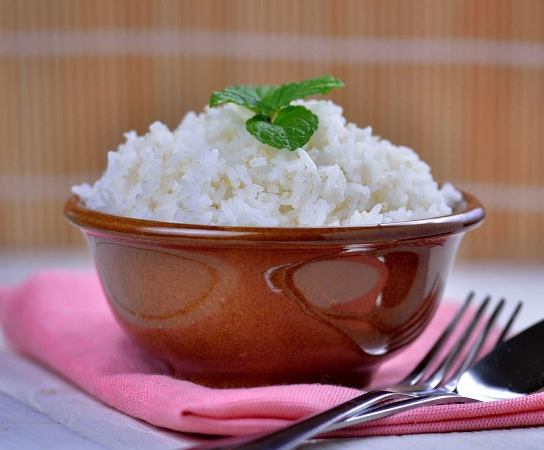 Cooked white rice garnished with mint in a ceramic bowl