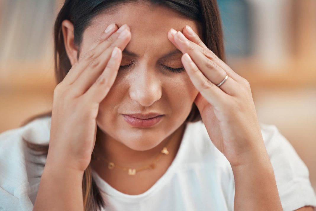 Headache, stress and anxiety with a business woman holding her h