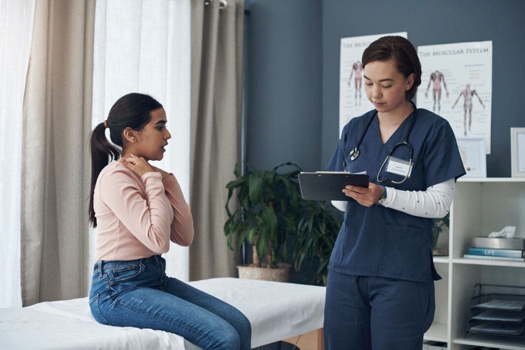 Shot of a young female doctor writing down a patients informatio