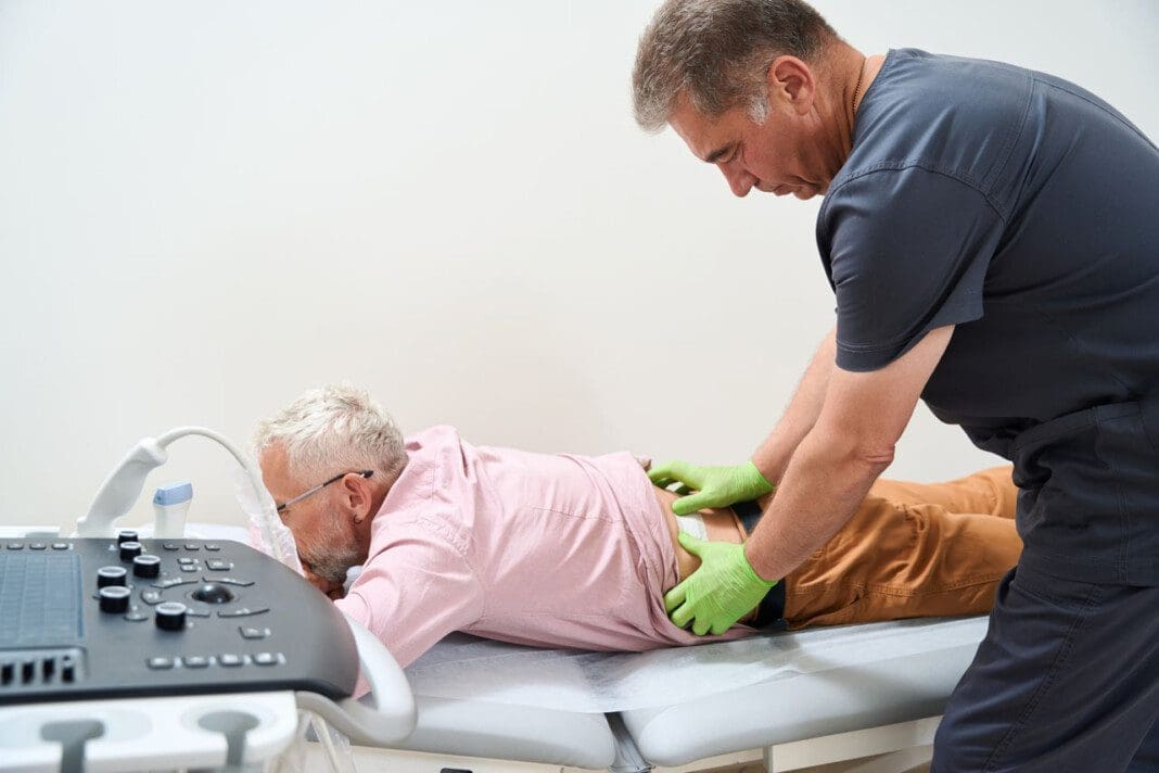 Experienced doctor examines the back of a gray-haired patient