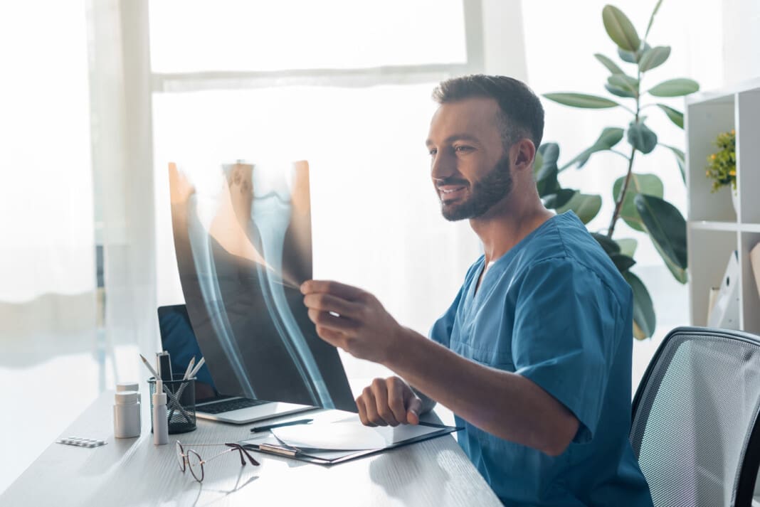 happy orthopedist looking at x-ray in clinic