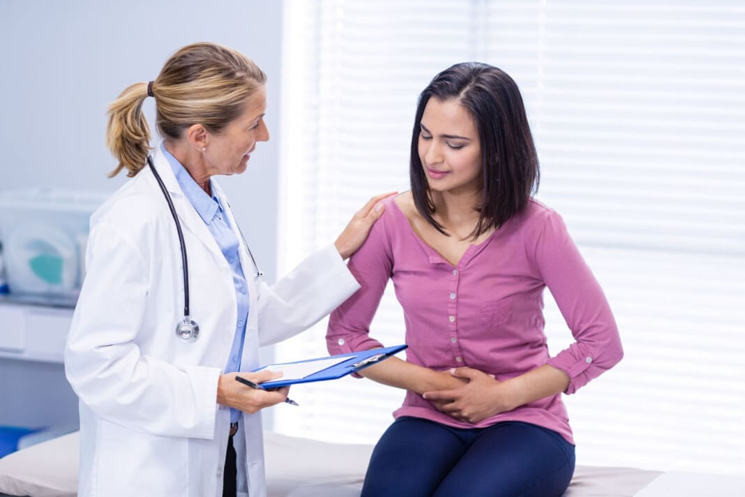 Patient suffering from stomach ache while consulting doctor