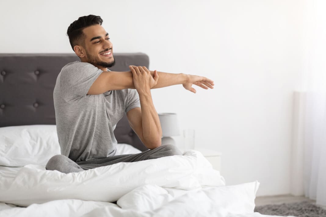 Middle Eastern Guy Waking Up In The Morning And Stretching In Bed