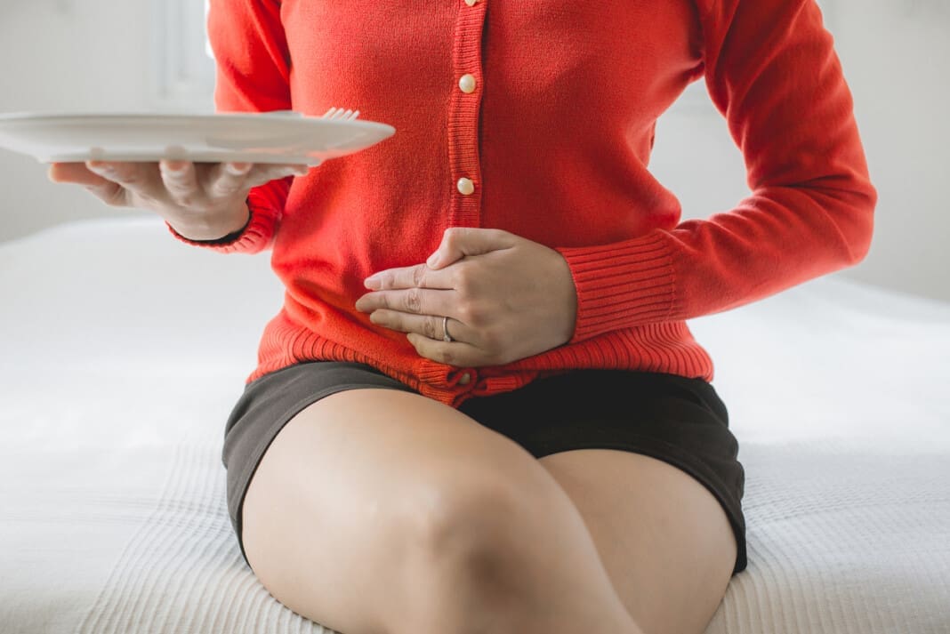 Digestion problems,Woman with stomach pain after eating,Hand female holding her belly