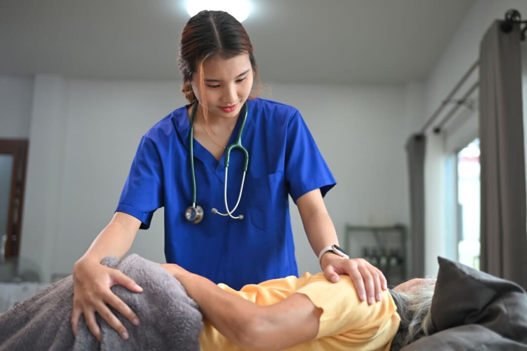 Physiotherapist or chiropractor doing manipulative spine treatment on mature patient