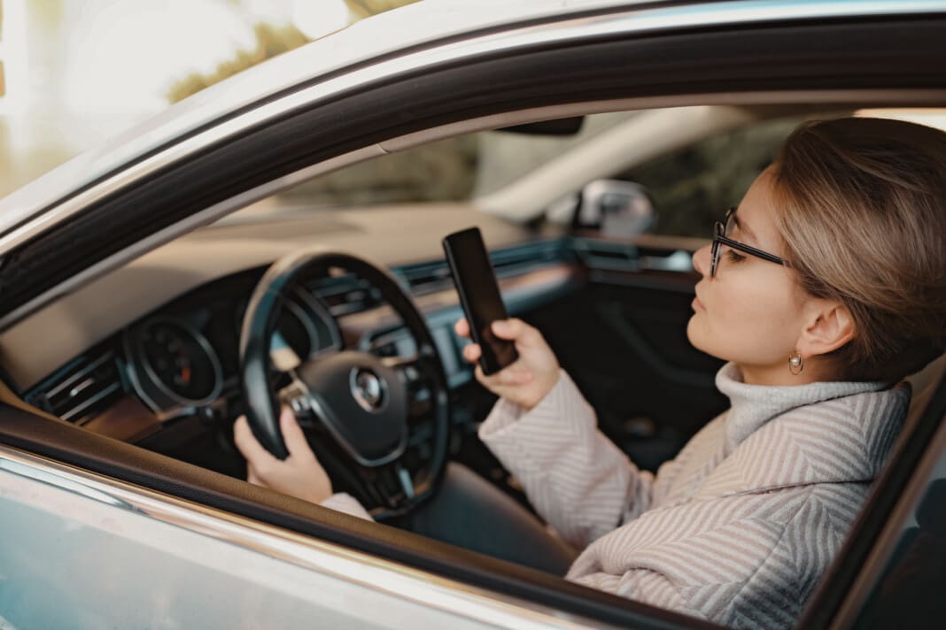 attractive stylish woman sitting in car dressed in coat